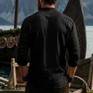 Detailed view of a black men's long sleeve linen shirt with mandarin collar in outdoor scenery.