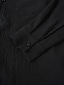 Primer plano detallado que muestra el puño, el botón y la textura de la camisa.