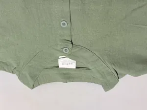 Close up view of the green linen blend shirt collar, showing fabric texture and buttons.