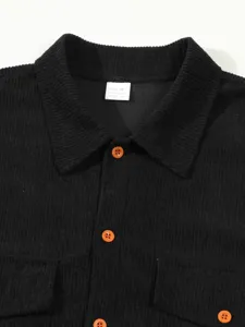 Vue detaillee du col de chemise en velours cote noir pour homme, boutons oranges, travail.