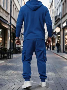 Detailed view of men's blue fleece hoodie and cargo pants set styled in street scene.