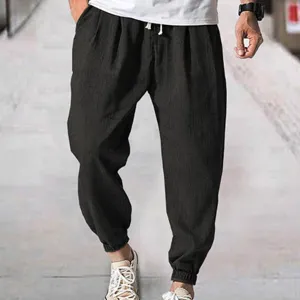 Men casual loose pants detail shot, black breathable drawstring jogger trousers for summer beach.