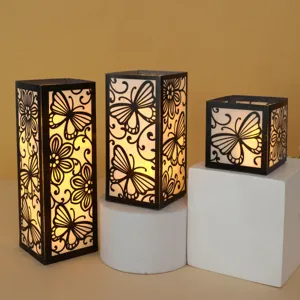 Vista detallada de tres cubiertas de linterna de mariposa DIY con luz cálida suave.
