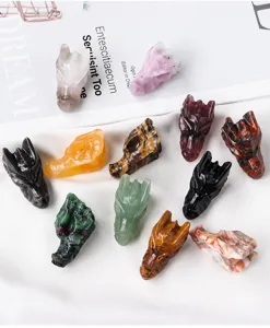 Primer plano de figuras de calaveras de dragón de cristal talladas en varias piedras naturales.