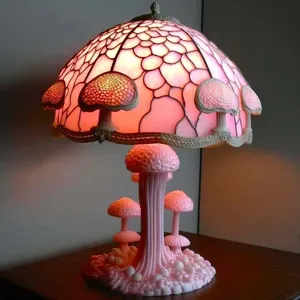 Vue détaillée d'une lampe champignon en vitrail rose avec un socle décoratif en résine