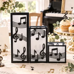 Vista detallada de tres farolillos de PVC con notas musicales en una mesa decorada con dulces