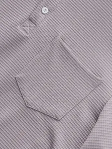 Close-up detail of men's long sleeve waffle knit henley shirt with pocket and button placket.