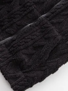Close-up detail of black fleece zip-up hoodie, soft texture and metal zipper design.