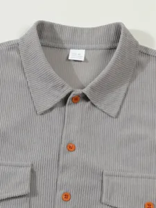 Vue détaillée du col de chemise en velours côtelé gris avec boutons et poche.