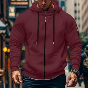 Detailed shot of men's burgundy full zip hoodie with sleeve pocket and drawstring hood style.