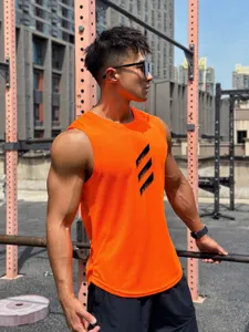 Close-up view of the orange breathable mesh sleeveless fitness tank top in outdoor gym.