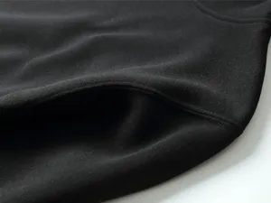 Close-up detail of black fleece hoodie showcasing fine pocket stitching and texture.