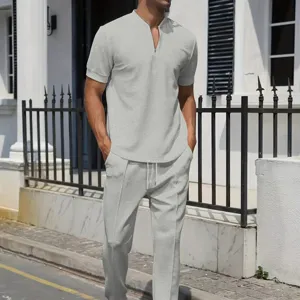 Outdoor detail view of men's grey waffle knit short-sleeve zip polo and pants set.