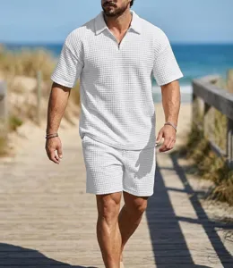 Detailed view of the white waffle knit men polo shirt and shorts set on beach boardwalk.