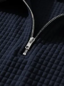 Close-up detail view of mens waffle knit polo shirt zipper and textured fabric style.