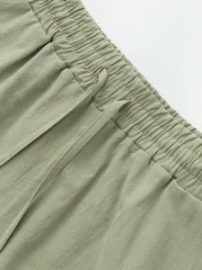 Close-up detail of men's casual linen shorts elastic waistband with drawstring in light green