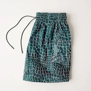 Detailed view of men's athletic mesh shorts with green digital crocodile print and drawstring.