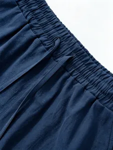 Detail shot of men blue linen shorts elastic waistband with adjustable drawstring design feature.