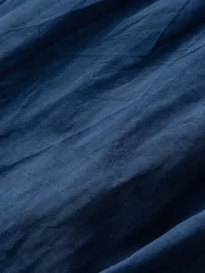 Close-up fabric detail of men casual cotton linen shorts showing soft texture and blue color.