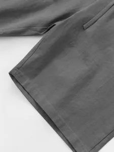 Grey linen shorts fabric detail showing elastic drawstring and fine stitching texture.