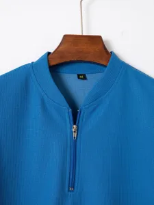 Blue waffle knit polo shirt collar detail, featuring metal zipper and size M neck label.