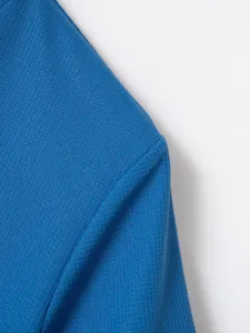 Close-up detail of blue waffle knit fabric showing fine texture and neat stitching.