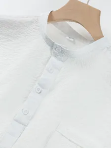 Close-up view of a white men's short sleeve mandarin collar seersucker shirt detail.