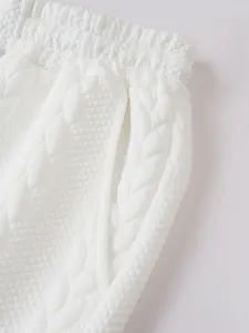 Close-up detail of men's white textured jacquard casual shorts featuring drawstring waistband.