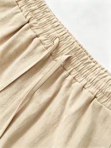 Men's cotton linen shorts waistband close-up detail, casual beige elastic drawstring.