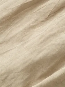 Close-up fabric detail of breathable linen shorts, showing natural texture and soft beige tone.