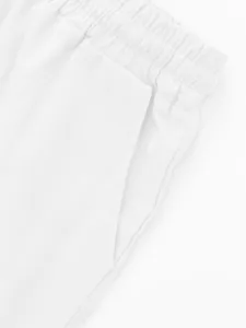Detailed view of men's solid color linen shorts featuring elastic waist and pockets.
