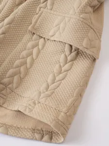Close-up detail of men's casual shorts pocket and textured jacquard fabric pattern.