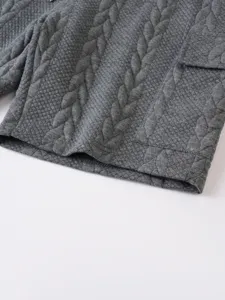 Close-up detail of grey cable knit casual shorts fabric, showing texture and pocket.