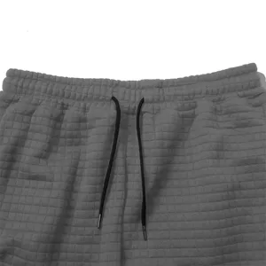 Men's waffle knit sweatpants detail view, comfortable grid fabric activewear pants.