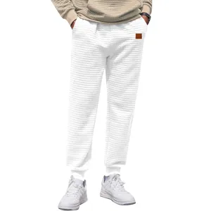 Detailed view of men white waffle sweatpants, comfortable checkered fabric joggers pants.