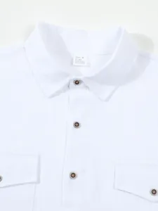 Close-up detail of white men's long-sleeve linen shirt collar, buttons, and fabric texture.