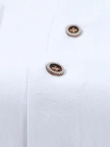 Men's casual linen shirt button detail close up, textured fabric, solid white long sleeve top.