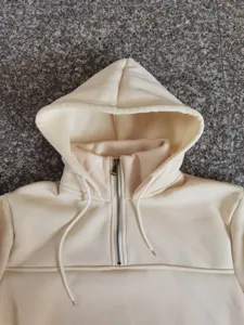 Nahaufnahme des Stehkragens mit halbem Reißverschluss und verstellbarer Kapuze aus Fleece.