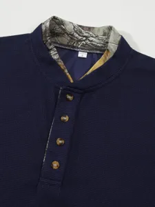 Men's waffle long sleeve Henley shirt detail view showcasing contrast camo collar and buttons.