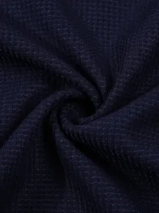 Detailed close-up view of dark blue waffle knit fabric texture, showing premium soft material.