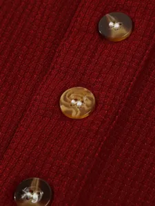 Close-up view showing the textured red ribbed fabric and marbled button details of the shirt.