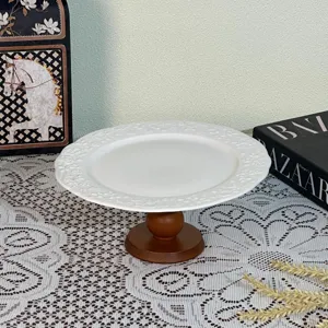 Detailed view of European palace relief ceramic fruit plate with wooden high foot stand.