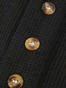 Detailed close-up shot of men's waffle knit long sleeve shirt with stylish marbled buttons.