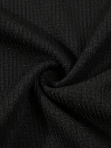 Black waffle knit fabric detail view, soft texture, premium quality basic t-shirt material.