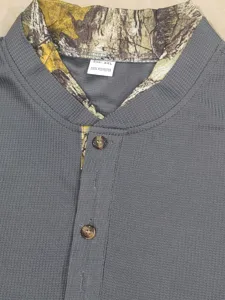Close-up detail of men's grey waffle-knit henley shirt with camouflage collar and buttons.