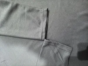 Grey waffle knit fabric texture detail showing sleeve cuff and material weave quality closely.