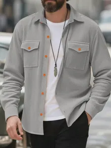 Chemise casual grise en velours côtelé pour homme avec poches poitrine et boutons oranges.