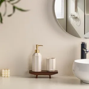 Minimalist ceramic bathroom soap dispenser and tumbler set detail view, elegant hotel style.
