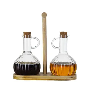 Glass oil and vinegar dispenser set with wooden tray and cork stoppers for kitchen use.
