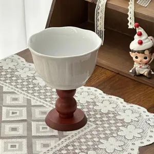 Detail shot of a retro ceramic dessert cup with a wooden base, elegant table setting.